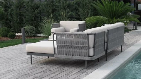 Modern sofa from outdoor collection by the pool in the garden of a luxury hotel Stock Footage 220773121