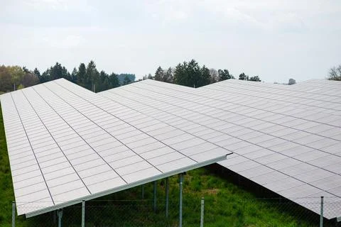 Modern solar panel array in green field Photos