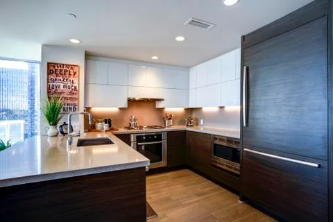 Modern spacious chef's kitchen design with white and black accents in luxurio Stock Photos