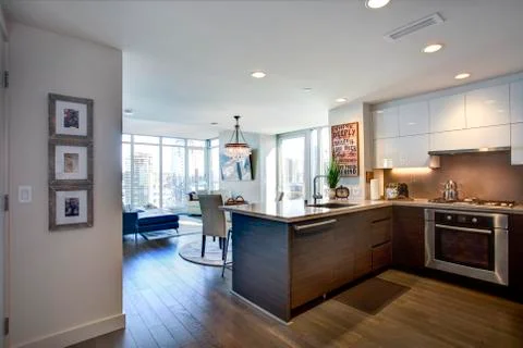Modern spacious chef's kitchen design with white kitchen cabinets in luxuriou Stock Photos