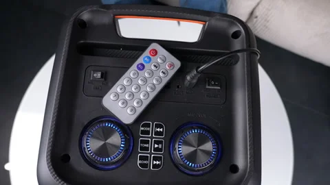 Modern speaker with remote control seen from the top, in a detailed closeup view Vidéo 276827224