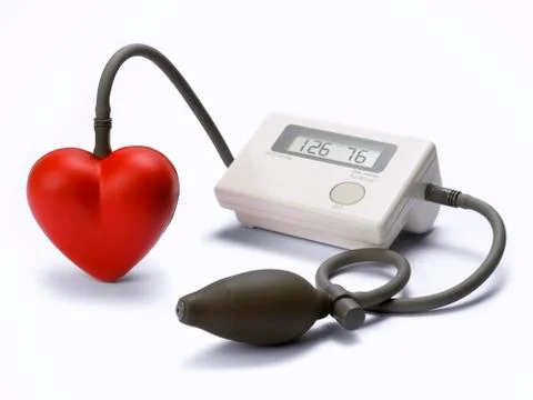 Modern sphygmomanometer, whose air bulb is a heart. White background. Stock Photos