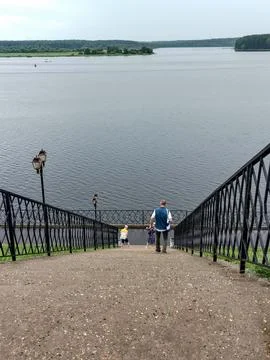 A modern staircase descends to the riverfront, a vertical Foto stock