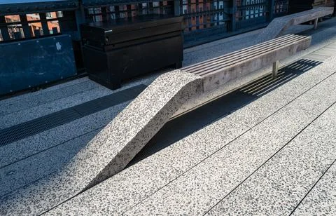 A modern stone bench on the High Line public park, casting an intriguing sh.. Stock Photos