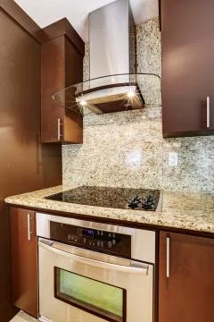 Modern stove with flat surface and steel hood Stock Photos