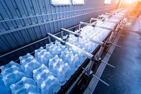 Modern strapping and transporting machine for packaging line at beverage plant. Stock Photos