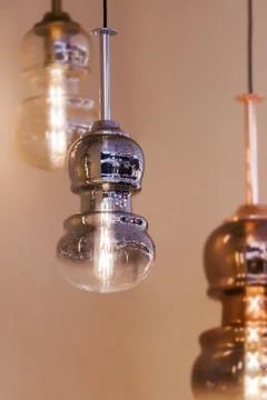 Modern streamlined mirror copper silver chandelier. Bubble metal glass shade  Stock Photos