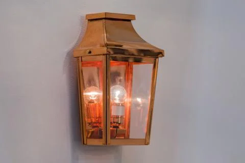 Modern streamlined mirror copper wall lamp. Metal classic lantern isolated on Stock Photos