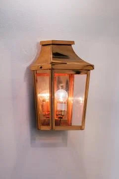 Modern streamlined mirror copper wall lamp. Metal classic lantern isolated on Stock Photos