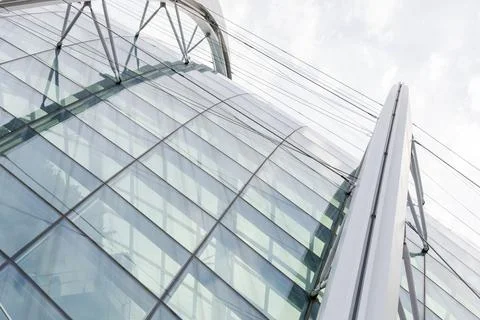 A modern structure with a large glass surface and metal elements is seen from Foto stock