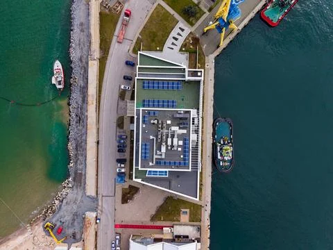 A modern structure is seen from above with solar panels on the roof. Nearby,  Fotos Stock