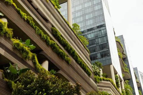 A modern structure stands tall with multiple levels covered in plants. The se Stock Photos