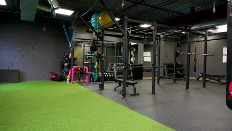 Modern studio gym interior with power rack and turf training zone Stock Footage 330620689