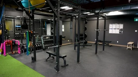 Modern studio gym strength training area with squat racks and functional Stock Footage 330620661