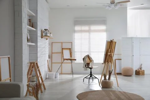 Modern studio interior with artist's workplace and foldable wooden easel near Foto stock