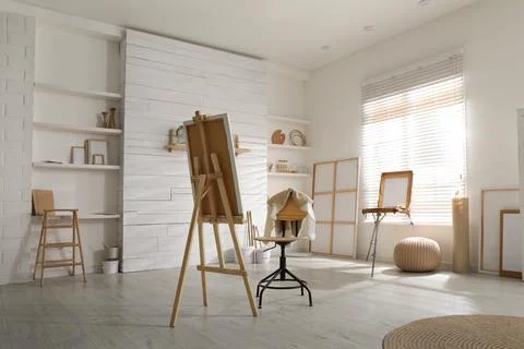 Modern studio interior with artist's workplace and foldable wooden easel near 写真素材