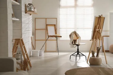 Modern studio interior with artist's workplace and foldable wooden easel near 写真素材