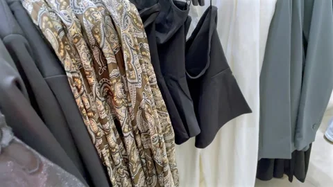 Modern stylish clothes hanging on a rack in a fashion retail store. Stock Footage 325448747