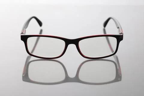 Modern stylish glasses with dark frames on table Stock Photos