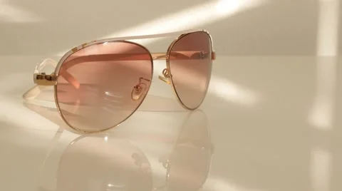 Modern sunglasses on white reflective surface close-up 4K 2160p UltraHD tilt Stock Footage 50898760