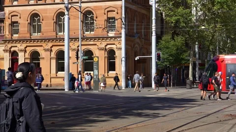 A modern Sydney Light Rail tram passes historic sandstone architecture as Stock Footage 345055030