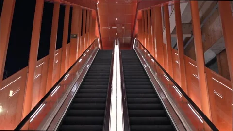 Modern symmetrical escalator inside vibrant orange architectural space Stock Footage 331768004