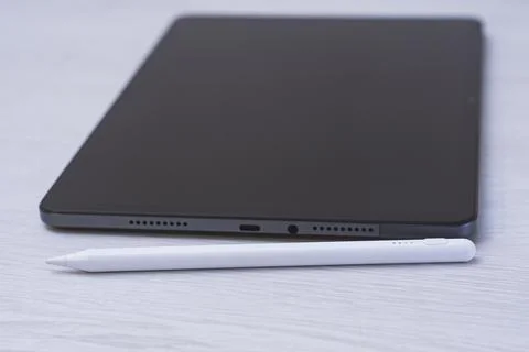 Modern tablet lying on a desk with a white stylus pen. Digital drawing, not.. Stock Photos