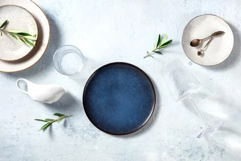 Modern tableware, overhead flat lay shot with a blue plate and olive branches 写真素材