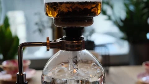 Modern tea brewing device making Chinese Pu-erh tea. Close-up of glass siphon Stock Footage 310382056