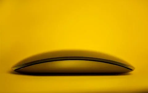 Modern tech wireless computer mouse on a yellow background. Foto stock