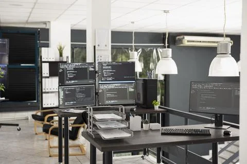 Modern tech workspace with multiple monitors filled with programming code 库存照片