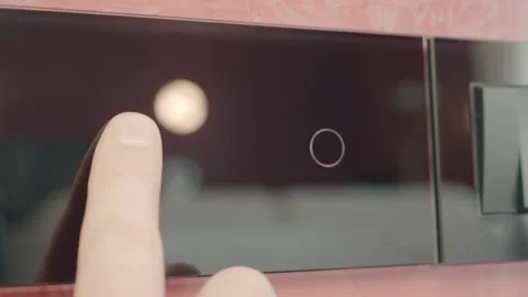 Modern technological black glass touch-sensitive light switch on the wall Stock Footage 297745698
