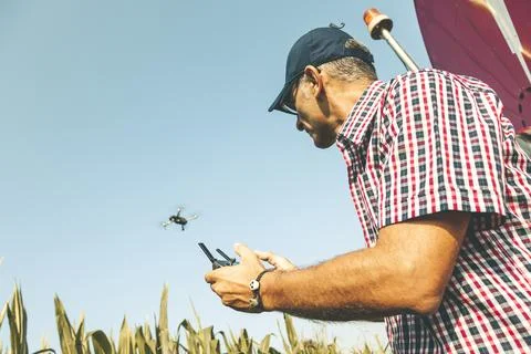 Modern technological farmer analyzing the growth of corn by flying a drone Stock Photos