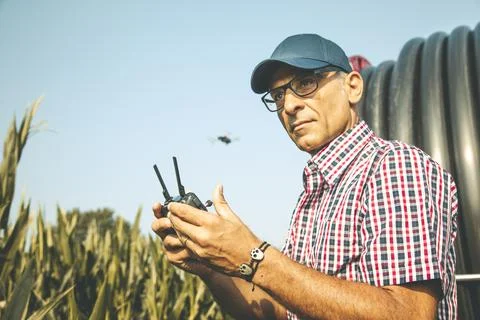 Modern technological farmer analyzing the growth of corn by flying a drone Stock Photos