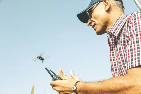 Modern technological farmer analyzing the growth of corn by flying a drone Stock Photos