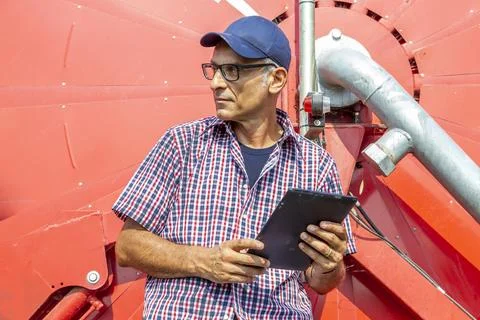 Modern technological farmer checking the growth data of corn on tablet Stock-Fotos