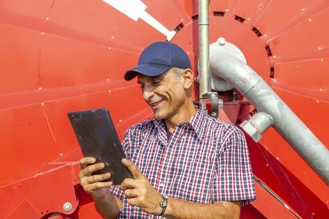 Modern technological farmer checking the growth data of corn on tablet Stock Photos