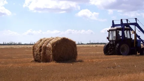 Modern technology agricultural tractor machine designed to collect bales of hay Stock Footage 94873711