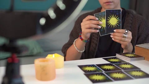 Modern technology. Female fortune teller holding a tarot card in front of the Stock Footage 252600581