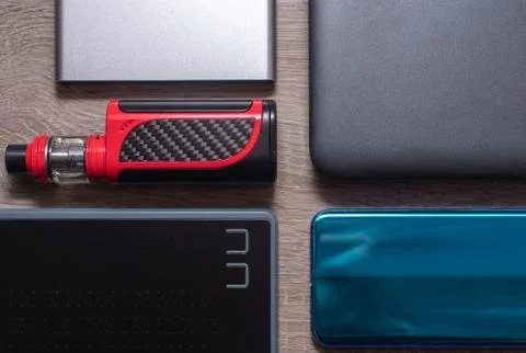 Modern technology flat lay, blue smartphone, silver powerbank, black graphic  Stock Photos