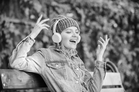 Modern technology instead of reading. listening music in park. hipster woman in Stock Photos