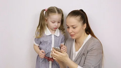 Modern technology. mom shows how to use the smartphone of her little daughter Stock Footage 106442600