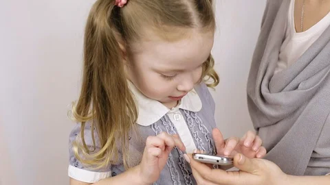 Modern technology. mom shows how to use the smartphone of her little daughter Stock Footage 106442781
