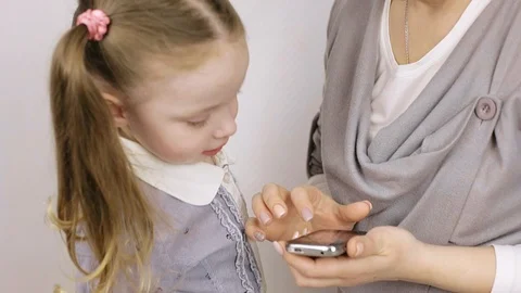 Modern technology. mom shows how to use the smartphone of her little daughter Stock Footage 106442846