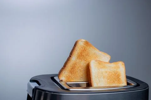 Modern toaster with crispy bread slices on white table Stock Photos