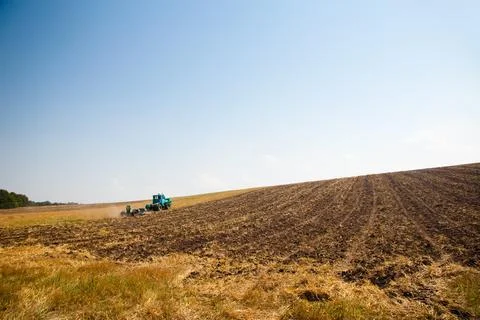 Modern tractor in the field with complex for the plowing. The concept of work in Stock Photos