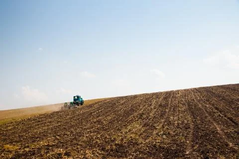 Modern tractor in the field with complex for the plowing. The concept of work in Stock Photos