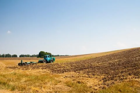 Modern tractor in the field with complex for the plowing. The concept of work in Stock Photos