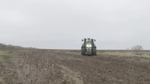 Modern tractor is going through field Stock Footage 70081811