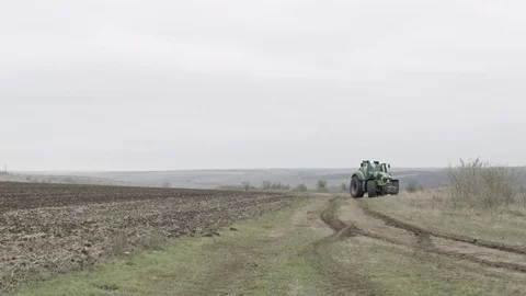 Modern tractor is going through field Stock Footage 70082180